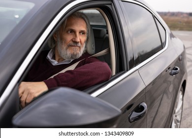 Handsome Older Man Is Driving His Car And Looking Trough The Window