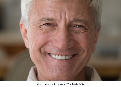 Handsome older man smiling staring at camera feels happy, close up face view. Senior advertise professional dental clinic, teeth repair and check up services, medical insurance cover for elder concept - Powered by Shutterstock