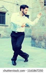 Handsome Passionate Man Dancing Alone Outdoors Against Old Stone Castle