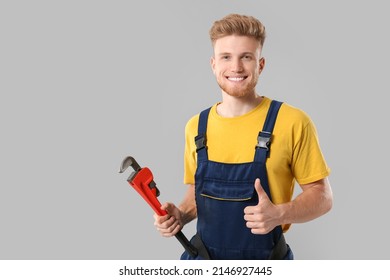 Handsome Plumber Showing Thumb-up On Grey Background