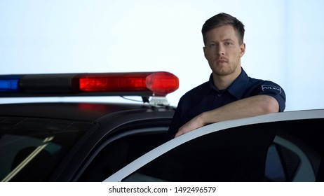 Handsome Police Officer Standing Near Car On Duty, Protection Of Public Safety