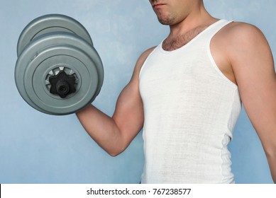 Handsome Power Athletic Man In Training Pumping Up Muscles With Dumbbell. Simple Not A Sports Not Muscular Guy Shakes Her Big Biceps Dumbbells. Home Exercise. Sports Lifestyle. Average Person