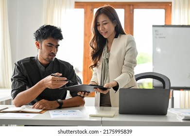 Handsome And Professional Asian Businessman Or Male Boss Looking At The Business Document On The Clipping Board With Female Assistant In The Office.