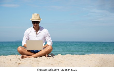 Handsome Relaxed Man Using Laptop, Beach Background, Freelance Working Social On Holiday Summer. Summer And Vacation Concept