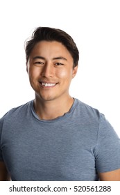 Handsome relaxed man wearing a tshirt and pants standing against a white background, relaxed looking.