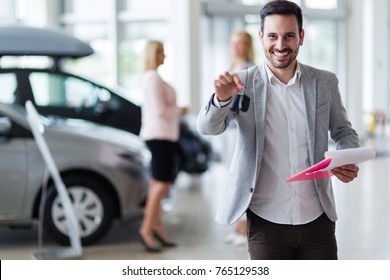 Handsome Salesman At Car Dealership Selling Vehichles