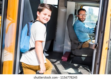 Handsome School Bus Driver And Schoolboy Looking At Camera