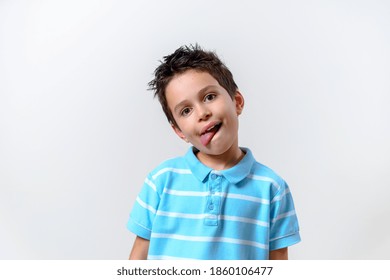 Handsome Sckoolboy, Adorable Child  Boy In A Blue T-shirt Bent Over His Head And Stuck Out His Tongue.Isolated Over White Background With Copy Space For Advertising. Facial Emotions 