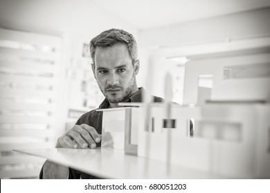 Handsome senior architect working on a construction project, he examines the model on which he works. Black and white - Powered by Shutterstock