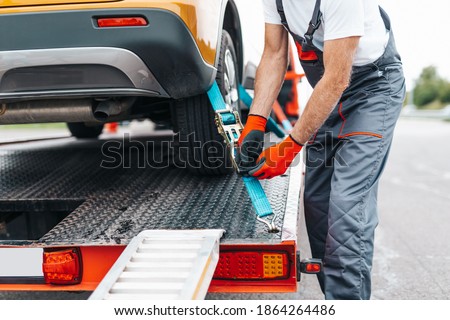 Handsome senior man working in towing service on the road. Roadside assistance concept.