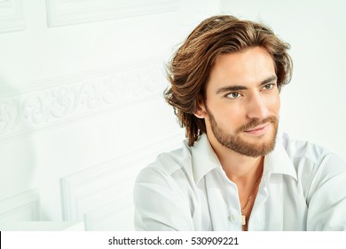 Handsome Sexy Man Wearing White Shirt Posing In Luxurious Interior. Men's Beauty, Fashion Model. Hair Styling.