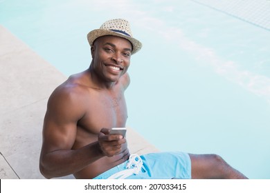 Handsome shirtless man texting on phone poolside on a sunny day - Powered by Shutterstock