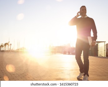 Handsome Silver Fox Man Talking On Mobile Phone Walking Outdoors At Sunset 