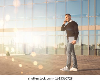 Handsome Silver Fox Man Talking On Mobile Phone With Glass Office Building In Background 