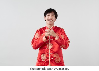 Handsome Smiling Asian Man In Traditional Oriental Costume Isolated On Light Gray Background For Chinese New Year Concepts