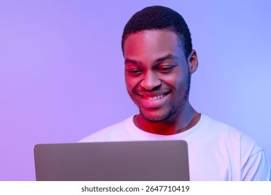 Handsome Smiling Black Programmer Guy Working Online On Laptop In Neon Light