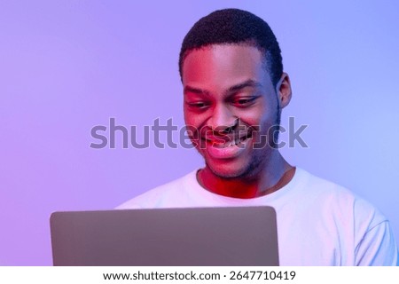 Handsome Smiling Black Programmer Guy Working Online On Laptop In Neon Light