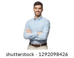 Handsome smiling business man in blue shirt standing with crossed arms, isolated on white background