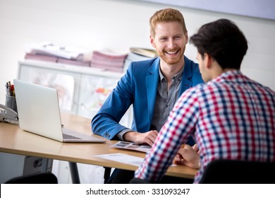 Handsome smiling car dealership salesman with costumer