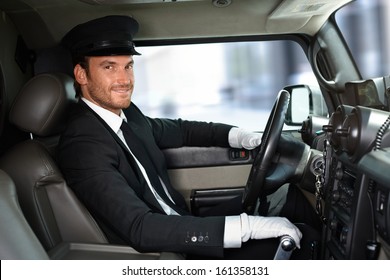 Handsome Smiling Chauffeur Driving Limousine.