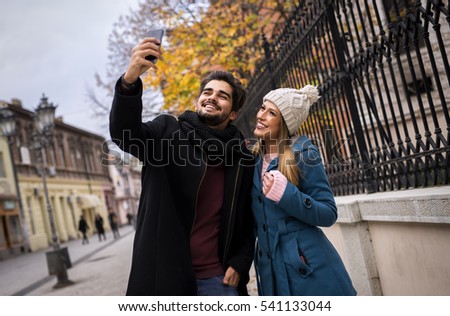 Similar – couple taking selfie in the street