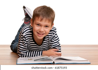 A handsome smiling kid is reading a thick book