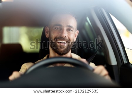 Handsome smiling latin man driving a car. Car sharing concept 