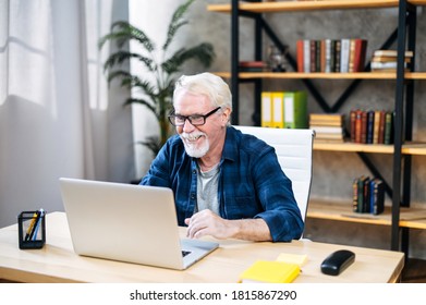 Handsome Smiling Older Man With Mustache And Beard Is Using A Laptop Computer At Home Office