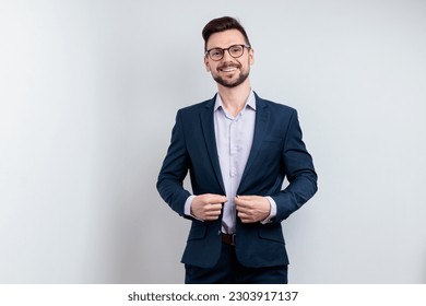 Handsome smiling young man fastens the buttons on his jacket  - Powered by Shutterstock