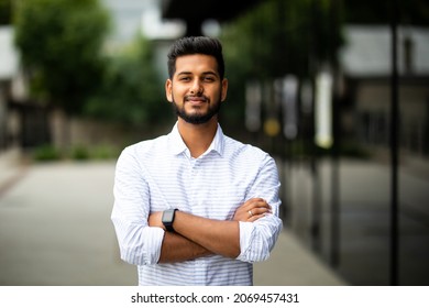 Handsome smiling young man with folded arms. Beautiful portrait of laughing joyful cheerful men with crossed hands in a city - Shutterstock ID 2069457431
