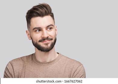 Handsome smiling young man isolated on gray background closeup portrait. Laughing joyful cheerful men studio shot