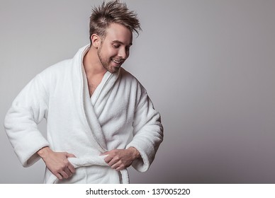 Handsome smiling young man in luxurious bathrobe.