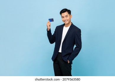 Handsome Southeast Asian Man In Standing And Showing Credit Card In Light Blue Color Isolated Studio Background