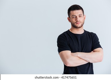 Handsome Sports Man Standing With Arms Folded Isolated On A White Background