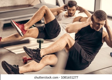 Handsome Sportsmen Doing Sit Ups Together In Gym