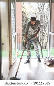 Handsome Stylish Man Using Hoover At Home