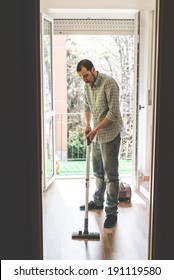 Handsome Stylish Man Using Hoover At Home