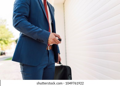 Handsome suited businessman opening garage, close up - Powered by Shutterstock