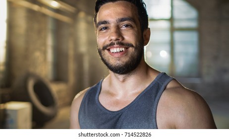 Handsome Sweaty Muscular Man Smiles on Camera. Sweat is dripping from His Face, He Wears Singlet. - Shutterstock ID 714522826