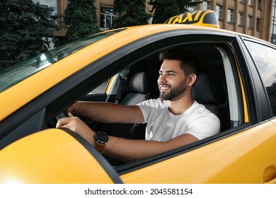 Handsome taxi driver in car on city street