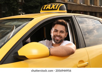 Handsome taxi driver in car on city street