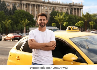 Handsome taxi driver near car on city street