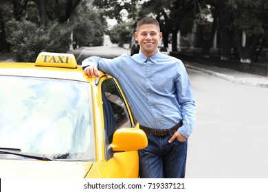 Handsome taxi driver near car on station