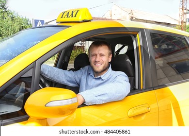 Handsome taxi driver sitting in car
