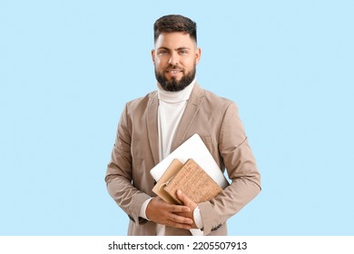 Handsome teacher of computer sciences with laptop and notebooks on blue background - Shutterstock ID 2205507913