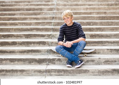 handsome teen boy sitting on skateboard - Powered by Shutterstock