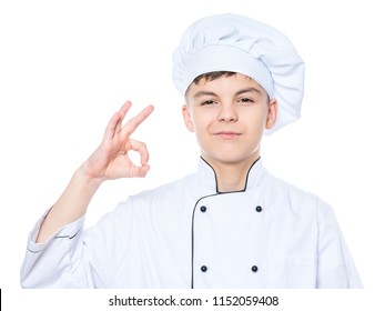 Handsome Teen Boy Wearing Chef Uniform Making Ok Gesture. Portrait Of A Happy Cute Male Child Cook, Isolated On White Background. Food And Cooking Concept.