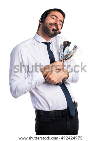 Handsome telemarketer man holding a trophy
