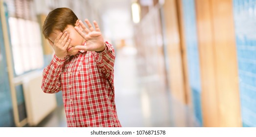 Handsome Toddler Child With Green Eyes Stressful And Shy Keeping Hand On Head, Tired And Frustrated At School Corridor