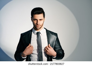 Handsome Trendy Man Posing In The Spotlight On Studio Background. Noir Film Style. Men's Beauty Concept